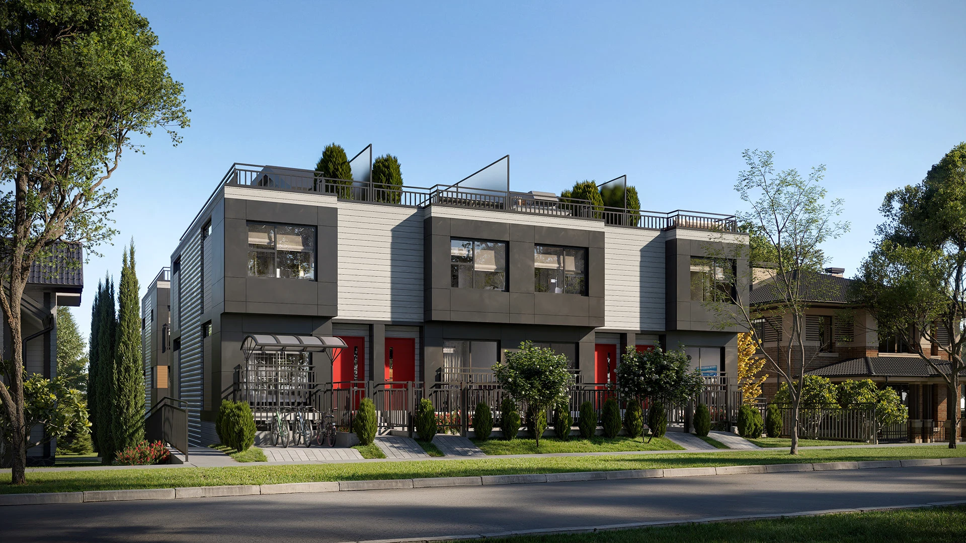 Fachada de casas adosadas de diseño moderno con techos planos y jardines frontales.